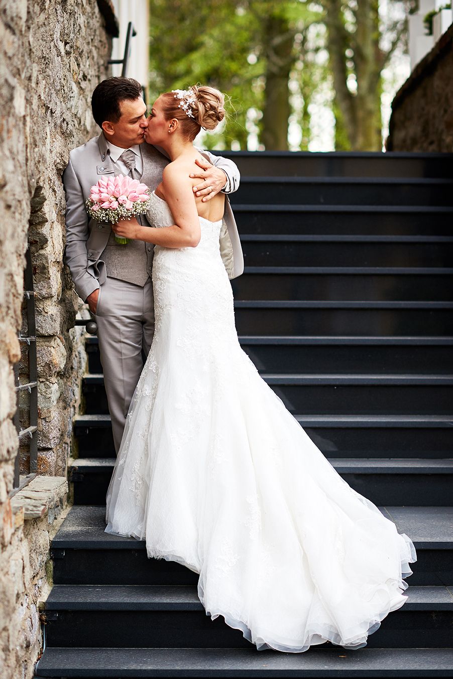 Hochzeitskuss auf Schlosstreppe im Frühling